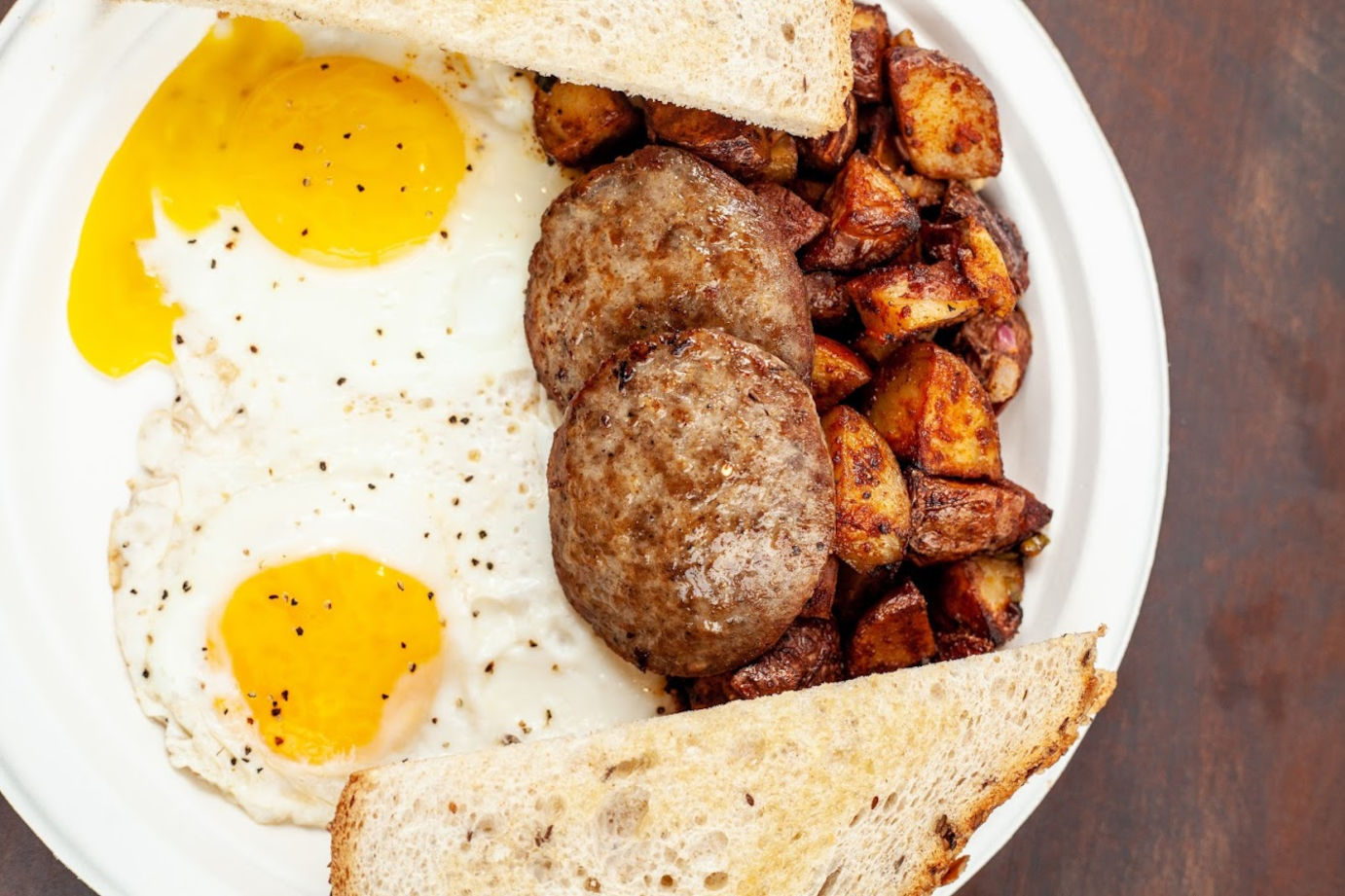 Two eggs, meat, potatoes and bread